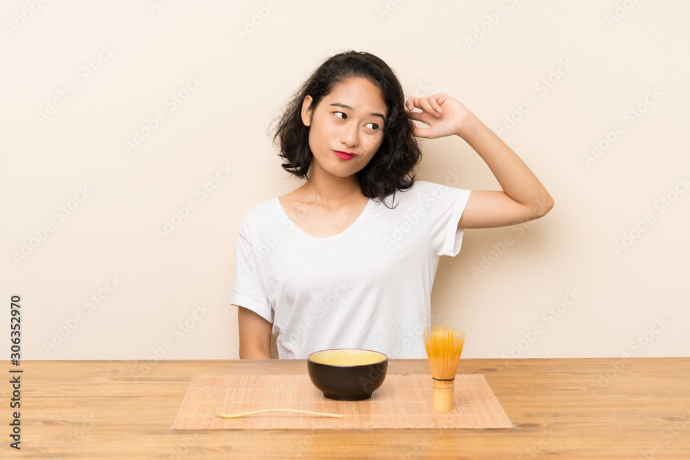 Young asian girl with tea matcha having doubts and with confuse face expression Young asian girl with tea matcha having doubts and with confuse face expression