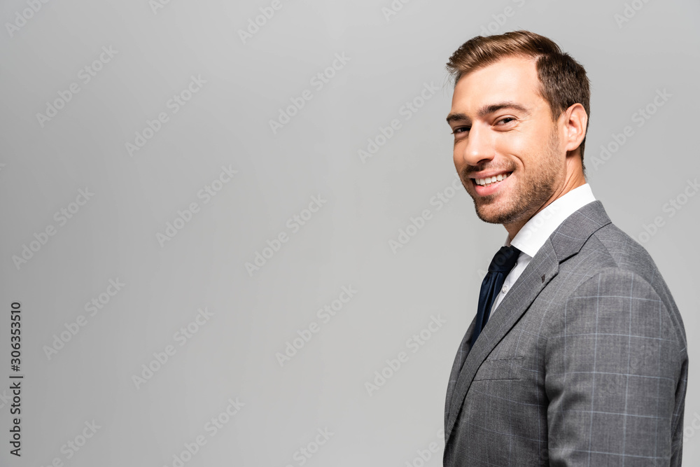 smiling and handsome businessman in suit looking at camera isolated on grey smiling and handsome businessman in suit looking at camera isolated on grey