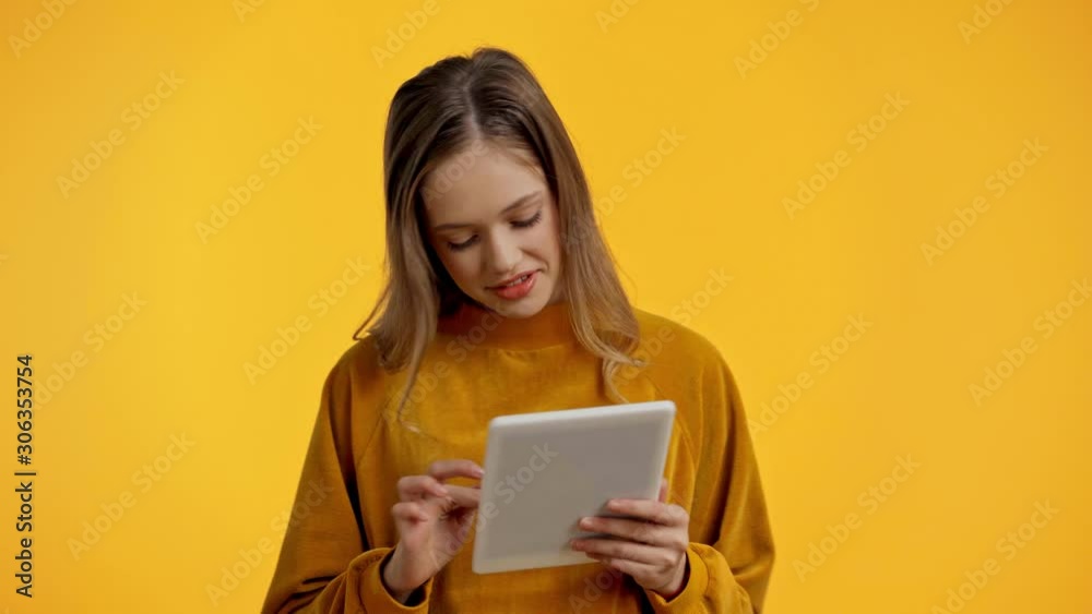 teenager using digital tablet isolated on yellow teenager using digital tablet isolated on yellow