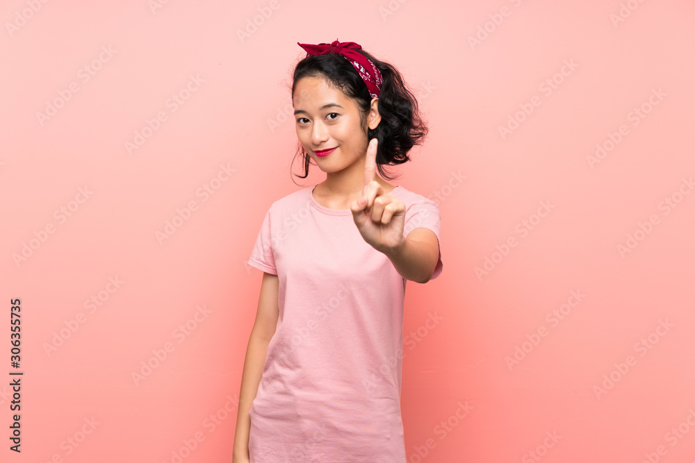 Asian young woman over isolated pink background showing and lifting a finger Asian young woman over isolated pink background showing and lifting a finger