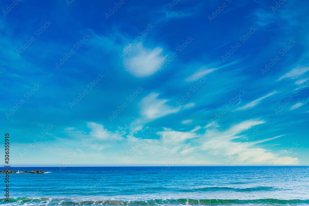 Beautiful clean blue sky, clouds, sea or ocean and waves at the beach in sunny day at summer time season. Sea and sky background. 