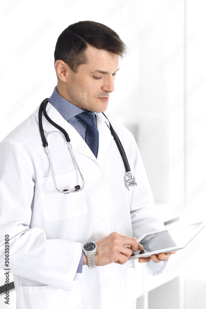 Doctor man using tablet computer for network research or virtual disease treatment. Perfect medical service in clinic. Happy future for modern medicine, medic data and healthcare concepts Doctor man using tablet computer for network research or virtual disease treatment. Perfect medical service in clinic. Happy future for modern medicine, medic data and healthcare concepts