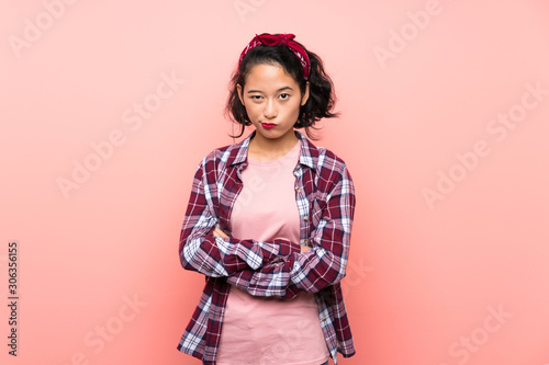 Asian young woman over isolated pink background feeling upset © luismolinero