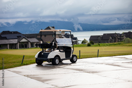 Wallpaper Mural Golf cart with houses, lake and mountains in the background Torontodigital.ca