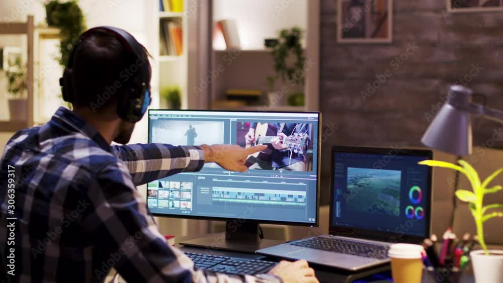 Film maker pointing at the monitor in home office Film maker pointing at the monitor in home office