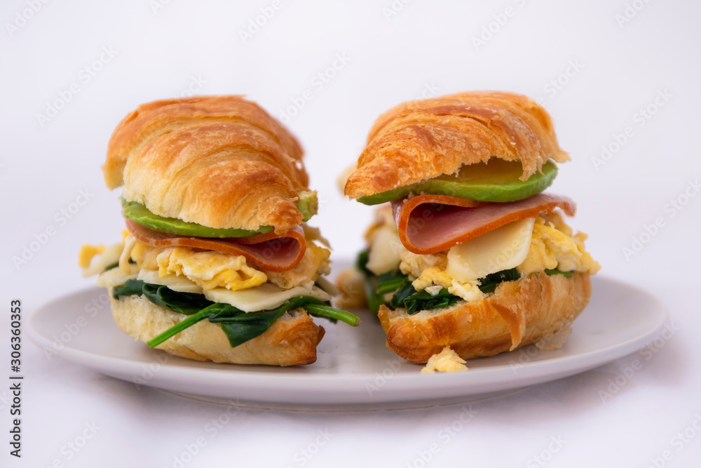 croissant sandwich of a ham, egg, spinach and avocado croissant sandwich of a ham, egg, spinach and avocado