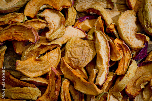 Dried sliced apples, healthy, closeup shot on a wooden surface.