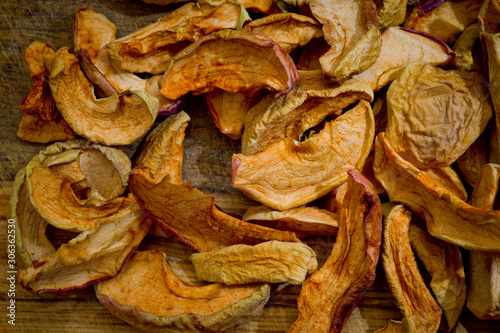 Dried sliced apples, healthy, closeup shot on a wooden surface.