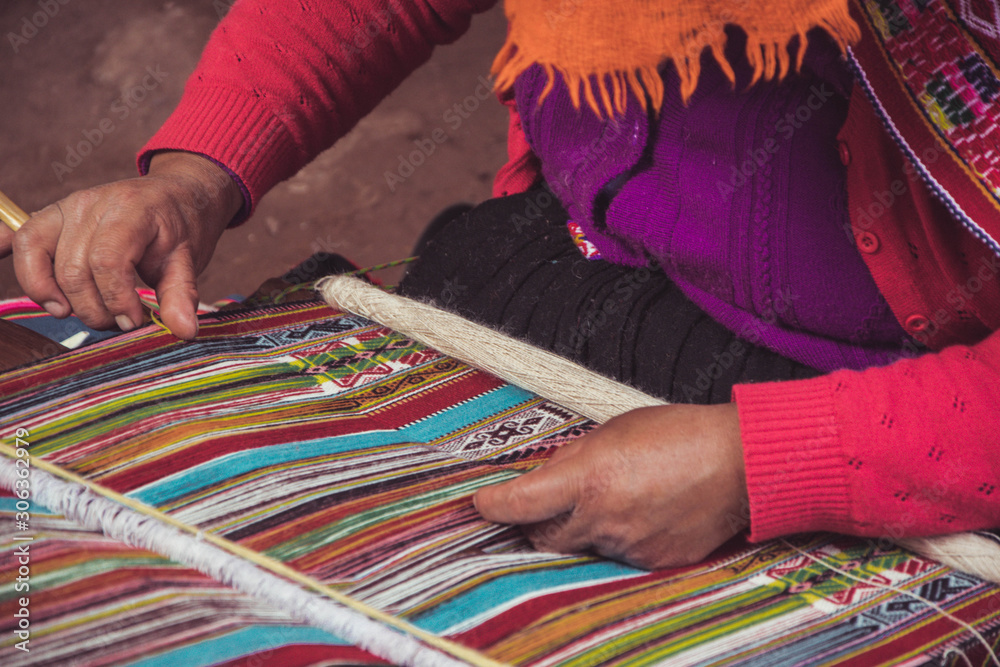 Textile artisan weaving a colorful hand-made blanket in Peru