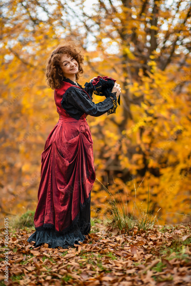 Portrait of a mature lady in a vintage dress, autumn time.