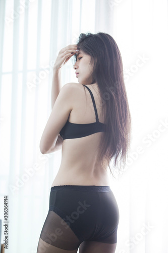 Sexy women wearing black lingerie doing various poses by the window of light