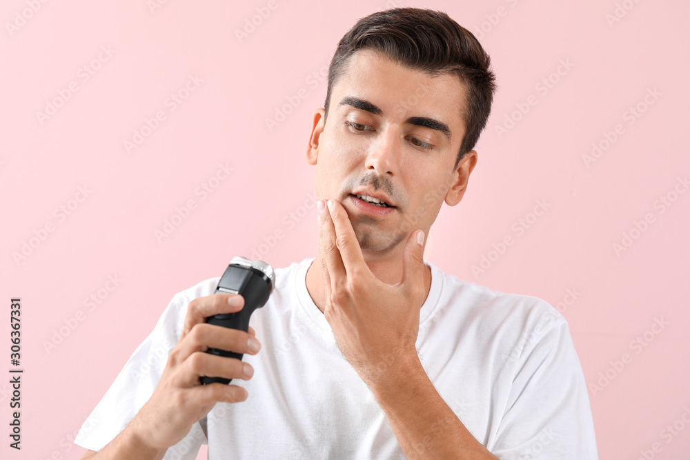Handsome young man shaving on color background Handsome young man shaving on color background