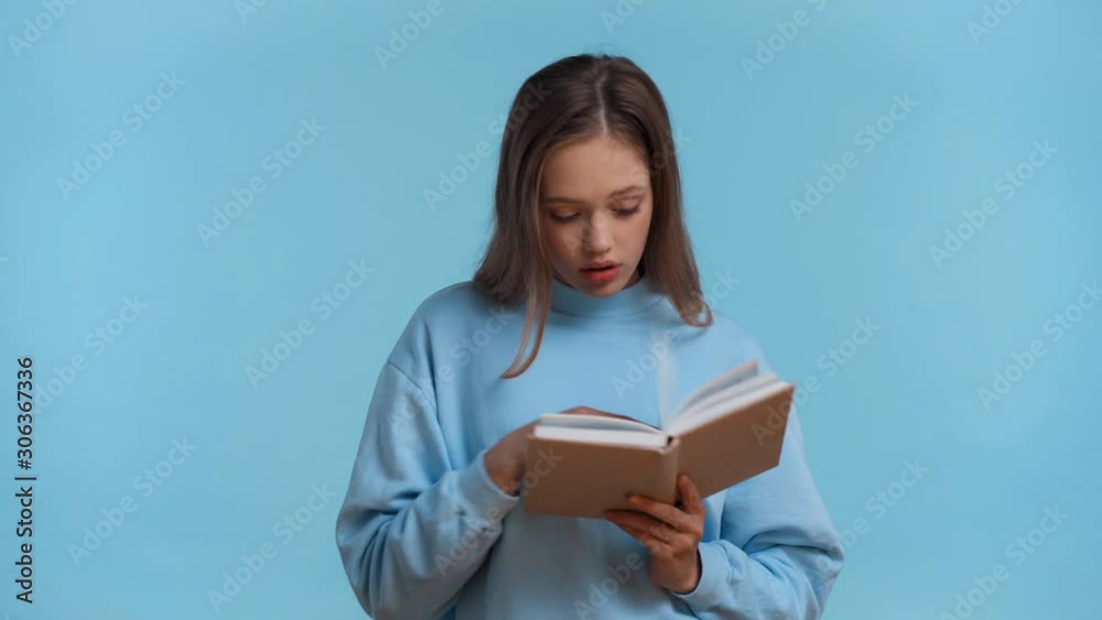 tense teenager reading book isolated on blue tense teenager reading book isolated on blue