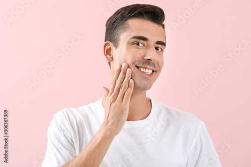 Handsome young shaved man on color background