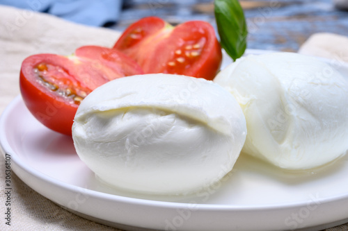 Cheese collection, organic mozzarella soft cheese served with ripe tomato and fresh green basil