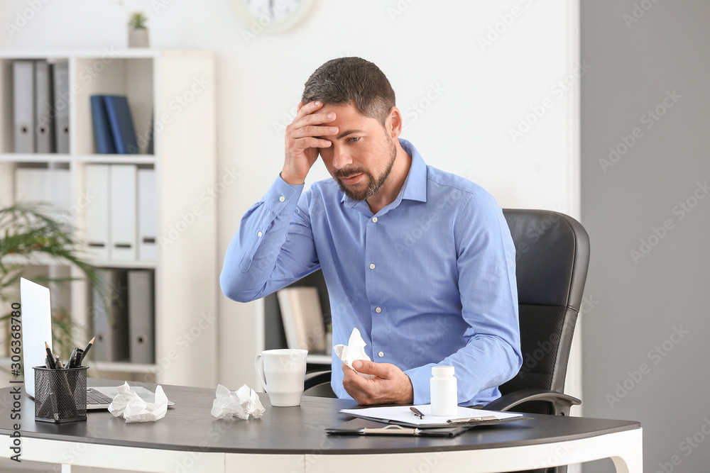 Man ill with flu working in office Man ill with flu working in office