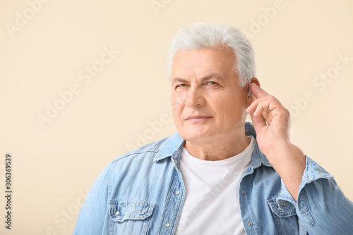 Mature man with hearing aid...
