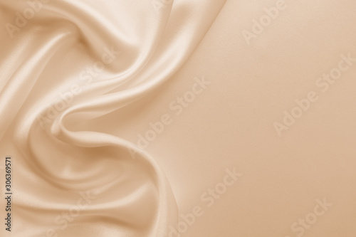 Beautiful smooth elegant wavy beige / light brown satin silk luxury cloth fabric texture, abstract background design. Copy space. Card or banner photo