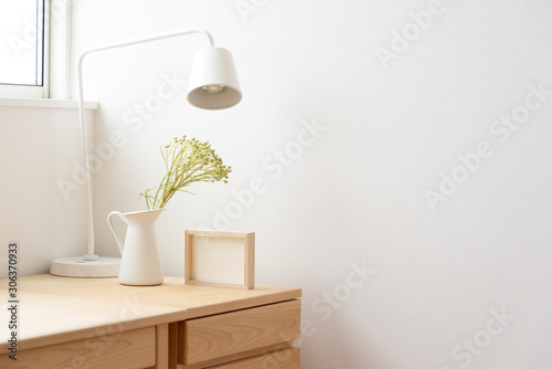 Minimalist Scandinavian-style desk with white lamp, plant in pitcher, and empty photo frame　北欧インテリアのデスクスペース　白木　机　観葉植物　