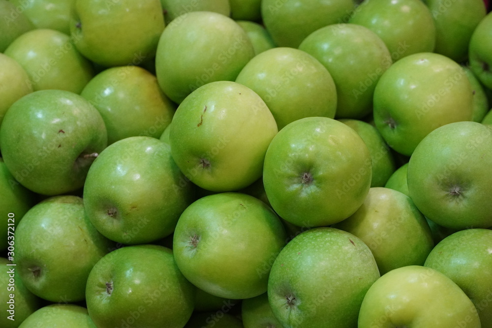 Bunch of green apples on boxes in supermarket. Apple put on sale shelves in the supermarket. Fresh ripe apples displayed beautifully. Bunch of green apples on boxes in supermarket. Apple put on sale shelves in the supermarket. Fresh ripe apples displayed beautifully.