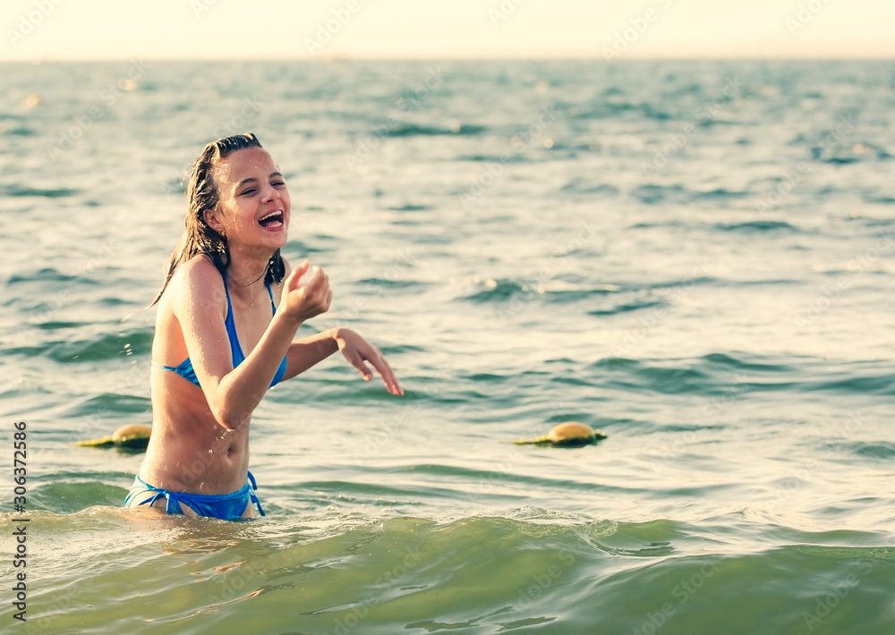 Portrait Of A Dark-haired Wet Laughing Woman Teen In A Swimsuit On A Summer  Evening In The Light Of The Setting Sun. Stock Photo, Picture and Royalty  Free Image. Image 135467873.