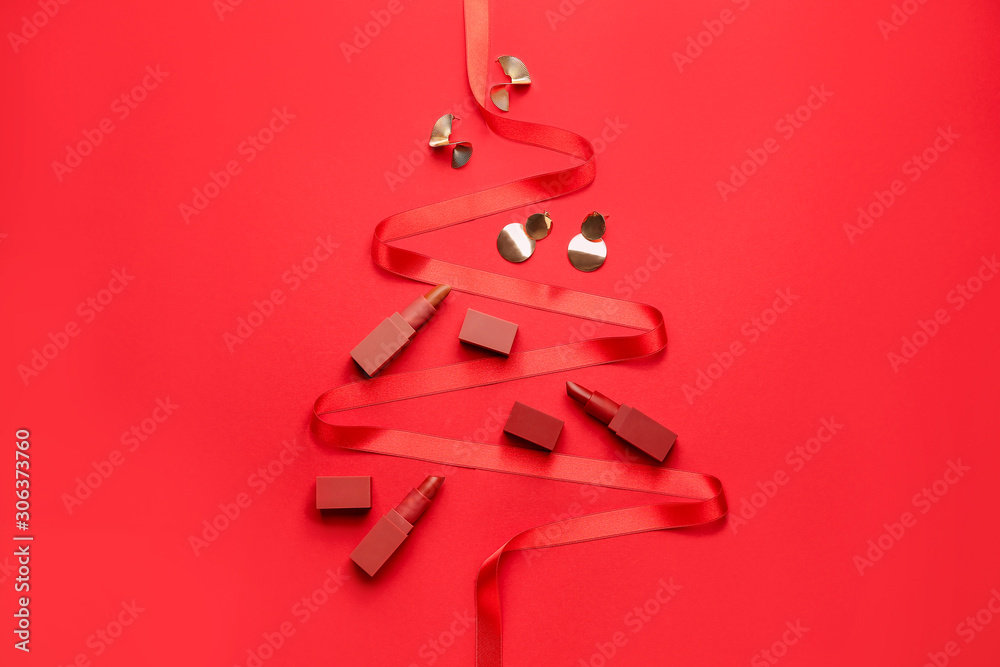 Beautiful Christmas tree made of lipsticks, jewelry and ribbon on color background