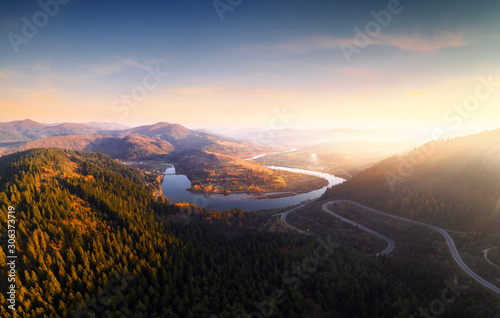 Photography Flight over the autumn mountains with mountain road serpentine