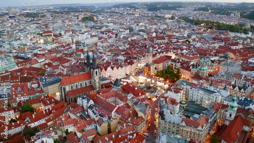 Aerial footage Church of Our Lady in old town district of Prague at twilight. Drone circling above famous cathedral. Panorama night city with illuminated streets and buildings. Lateral motion shot photo