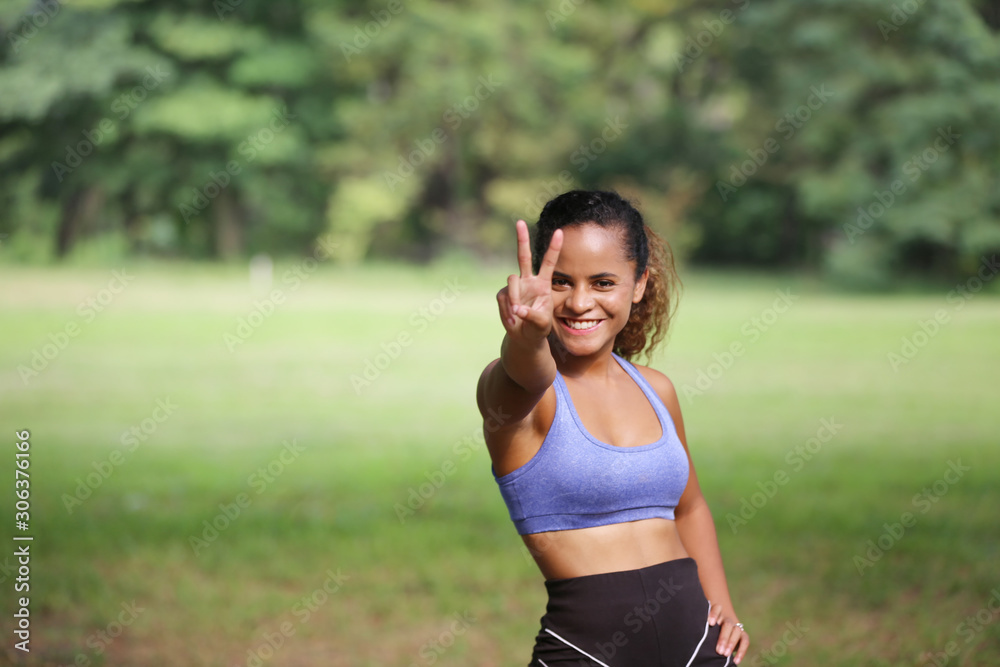 Healthy beautiful sportswoman wearing tracksuit show two finger in the park, African american women Healthy beautiful sportswoman wearing tracksuit show two finger in the park, African american women