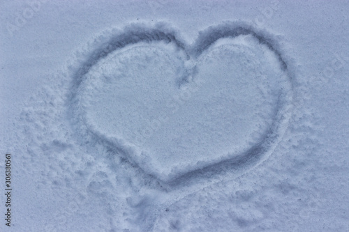 Heart drawn on the snow, winter cold weather. Love despite snowfall and cold. Tender feelings squabble a blizzard