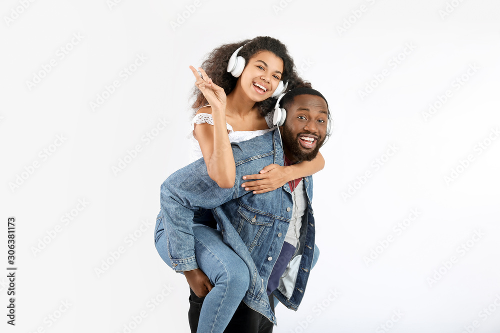 Happy African-American couple with headphones on white background Happy African-American couple with headphones on white background