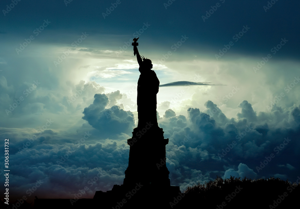 Silhouette of Statue of Liberty over dramatic skies, New York, USA Silhouette of Statue of Liberty over dramatic skies, New York, USA