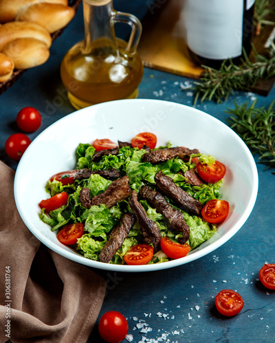 bowl of beef salad with lettuce and cherry tomato