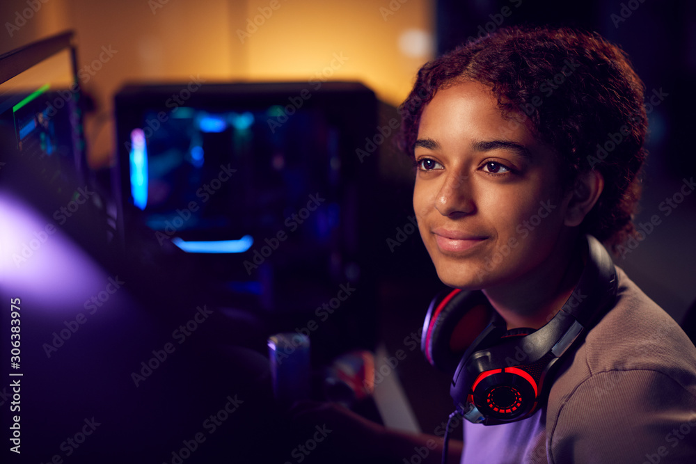 Teenage Girl With Headset Gaming At Home Using Dual Computer Screens Teenage Girl With Headset Gaming At Home Using Dual Computer Screens