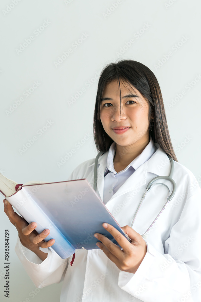 student medicine or young Asian female doctor holding textbook for learning in medical treatment patient, white uniform, smiling in healthcare at hospital, post for advertising doctor's career concept student medicine or young Asian female doctor holding textbook for learning in medical treatment patient, white uniform, smiling in healthcare at hospital, post for advertising doctor's career concept