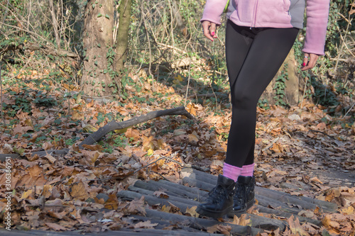 Healthy life in nature, young woman sporty dressed hiking, crossing small bridge made of timber