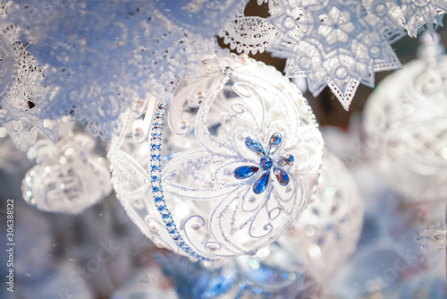 White textile soft christmas and new year decorations - xmas ball. Handmade, lace, threads with blue snowflake on christmas ball. Sell on the market for christmas tree.