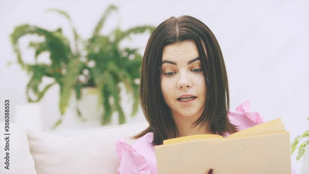 Inquisitive young female is involved in excited process of reading.
