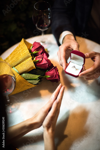 cropped view of man presenting wedding ring to girlfriend while making marriage proposal