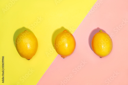 Pattern of lemons on yellow and pastel pink background.