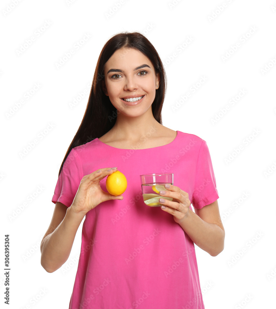 Beautiful young woman with tasty lemon water and fresh fruit on white background