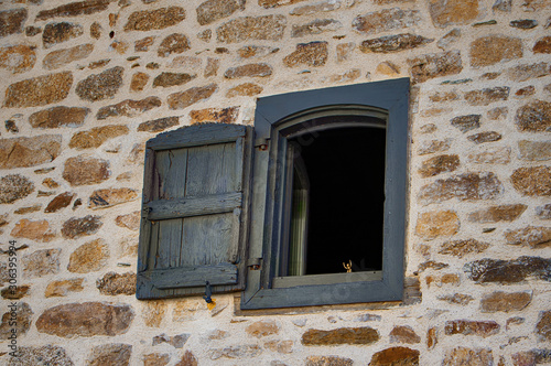 Une petite figurine dans la fenêtre d'une ancienne maison à Marcolès - une commune française, située dans le département du Cantal en région Auvergne-Rhône-Alpes.