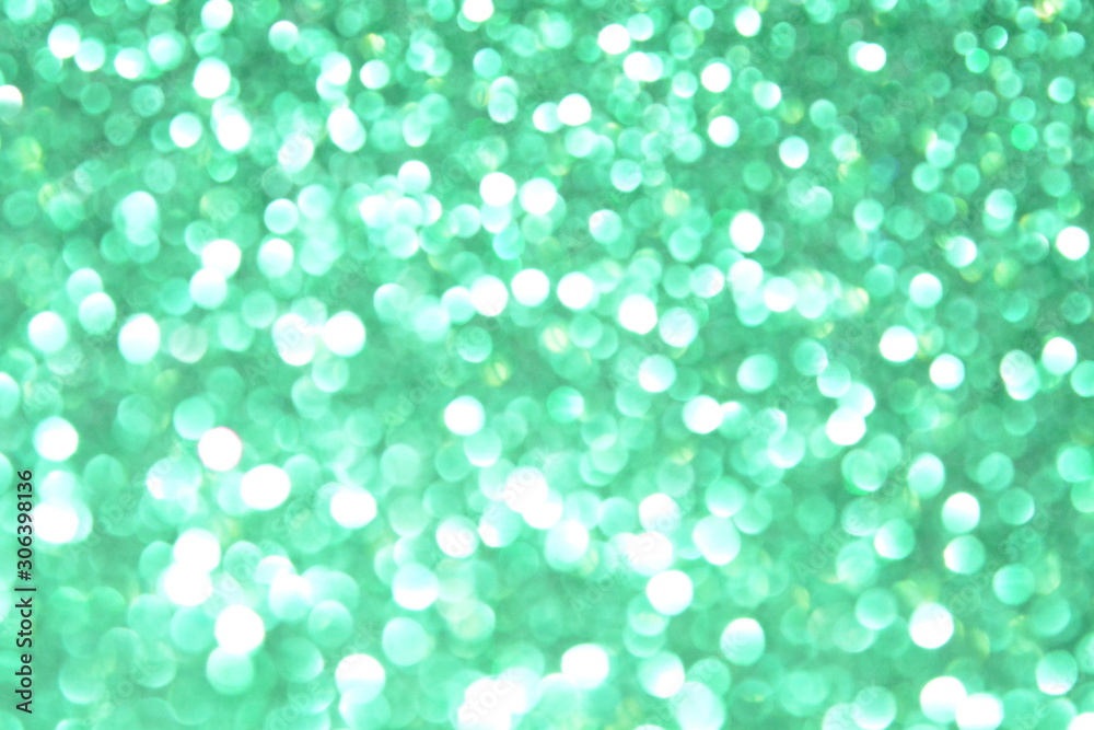 Beautiful Abstract Defocused Sparkle Glitter Lights Background. Green Emerald. Shine Bokeh Effect. For party, holidays, celebration.