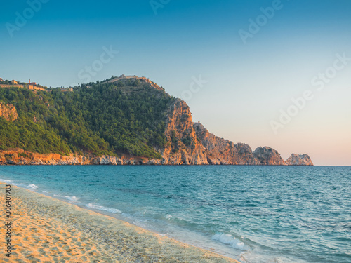 Fototapeta Naklejka Na Ścianę i Meble -  Alanya, Turkey. Beautiful view of the ancient fortress Alanya Castle on the mountain from Cleopatra beach. Vacation postcard background