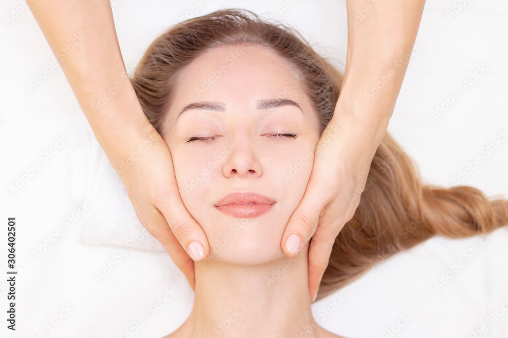 Young woman enjoying massage in spa salon. Face massage. Closeup of young woman getting spa massage treatment at beauty spa salon.Spa skin and body care. Facial beauty treatment.Cosmetology. Young woman enjoying massage in spa salon. Face massage. Closeup of young woman getting spa massage treatment at beauty spa salon.Spa skin and body care. Facial beauty treatment.Cosmetology.