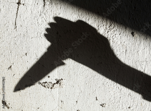 Shadow of the hand holding a knife photo