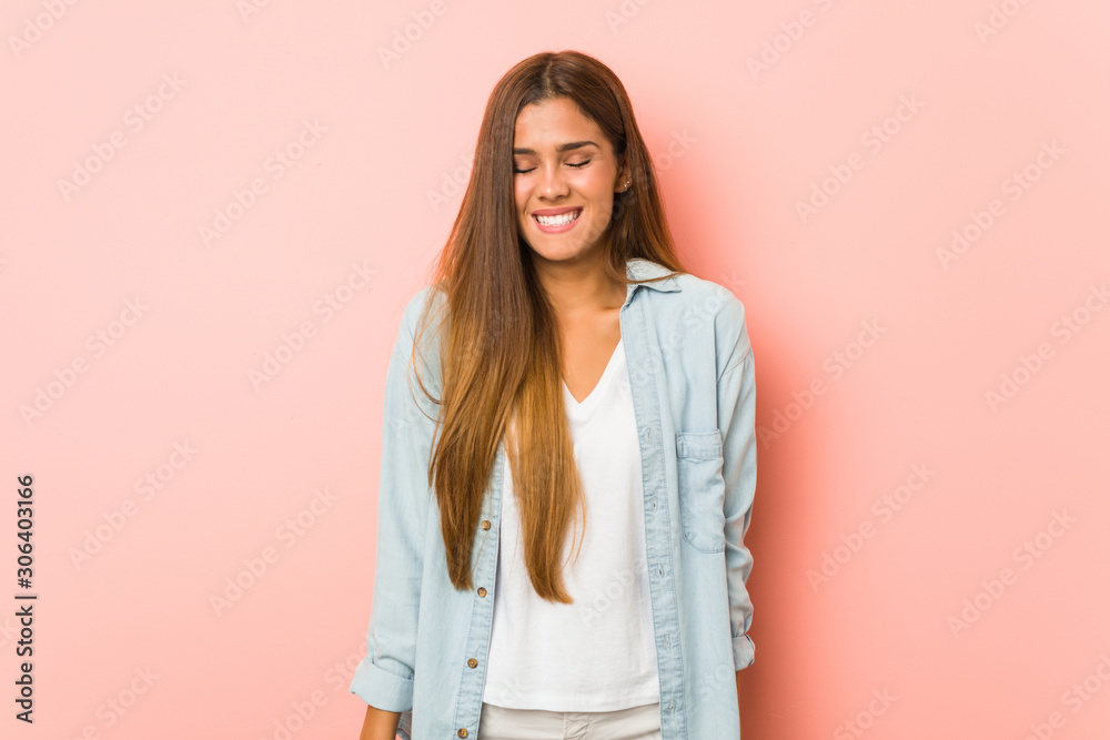 Fototapeta premium Young slim woman laughs and closes eyes, feels relaxed and happy.