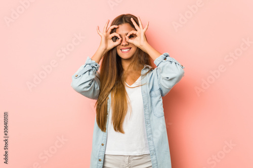 Young slim woman showing okay sign over eyes © Asier