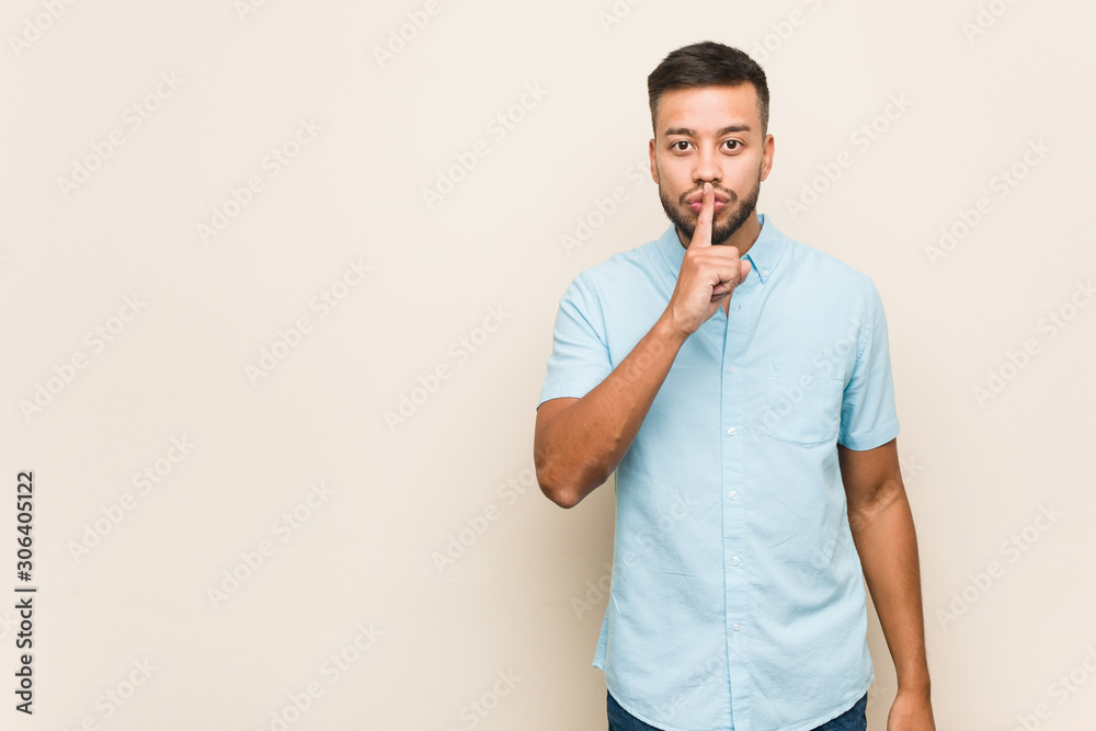 Young south-asian man keeping a secret or asking for silence. Young south-asian man keeping a secret or asking for silence.