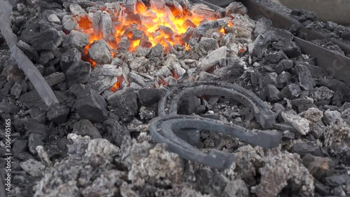 Wallpaper Mural A pair of horseshoes cools in a forging brazier. Annealing and heat-treating of iron parts for forging. The camera moves from the  flame to the horseshoes.  Torontodigital.ca